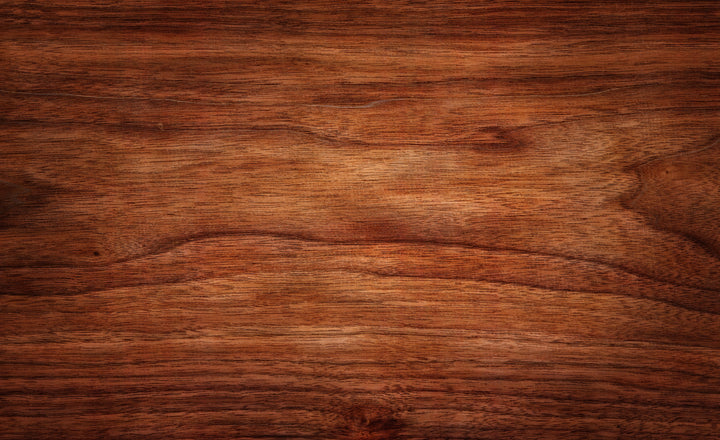 Close-up of walnut grain, warm light raking across the finish